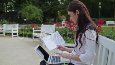 <strong>女士</strong>坐在公园里，<strong>用笔记本电脑</strong>。 数据输入